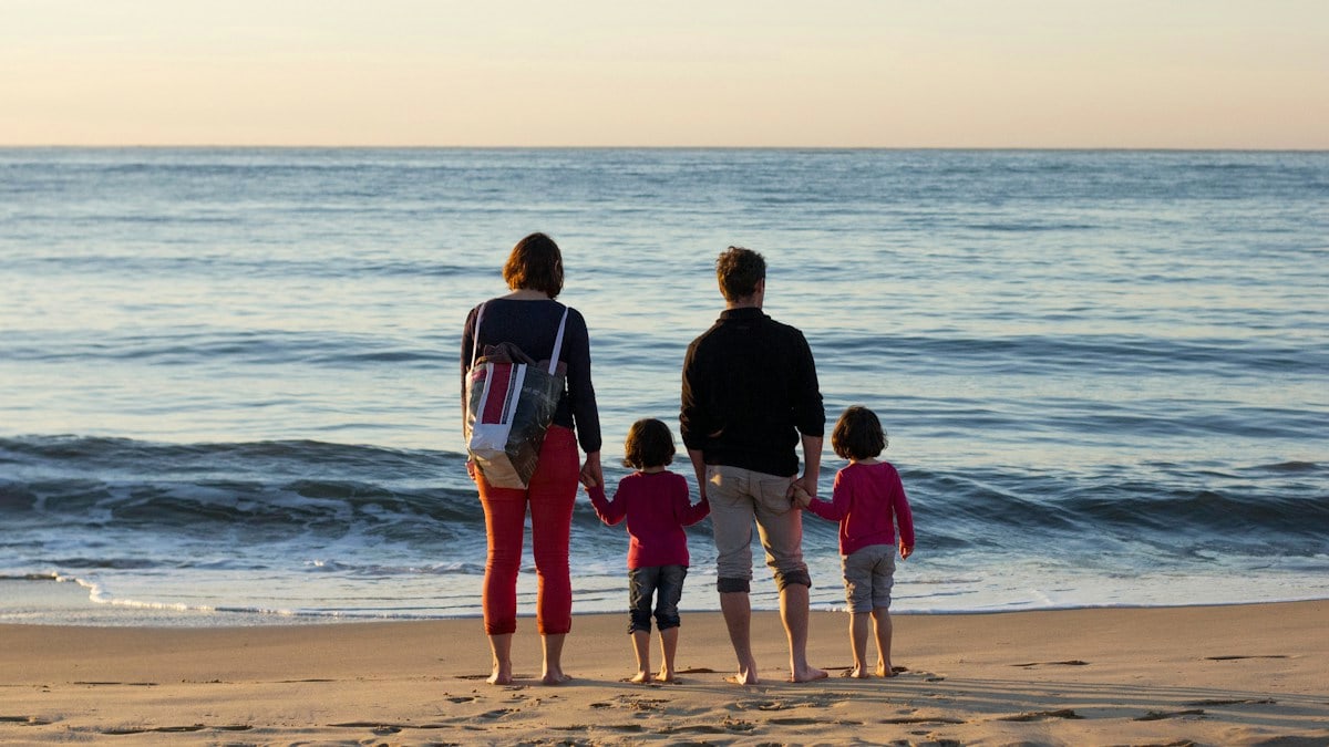 family of four standing at the seashore